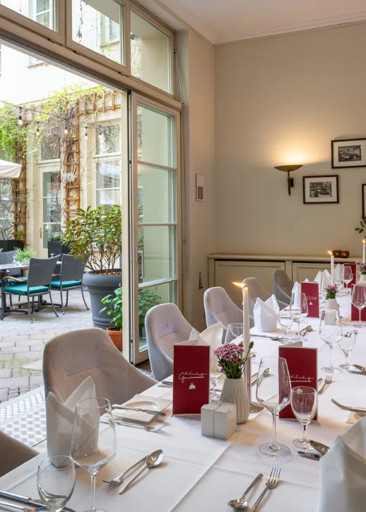 Gedeckter Tisch im Restaurant Alvis in Berlin, dekoriert mit stilvollen Tellern und Gläsern.