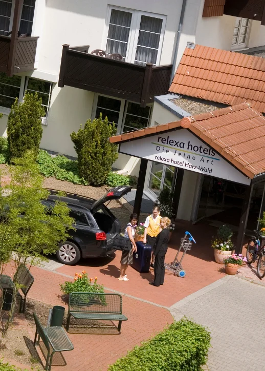 Menschen stehen vor einem Hotel und halten Fahrräder in der Hand.
