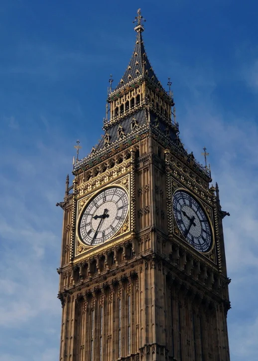 Big Ben, der große Uhrturm, strahlt unter einem klaren blauen Himmel in London.