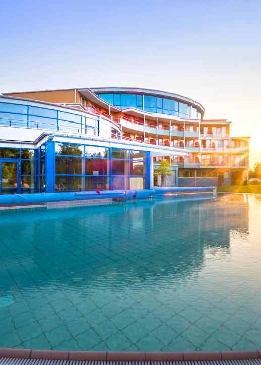 Weitläufiger Swimmingpool vor einem modernen Gebäude, ideal für Erholung und Freizeit.