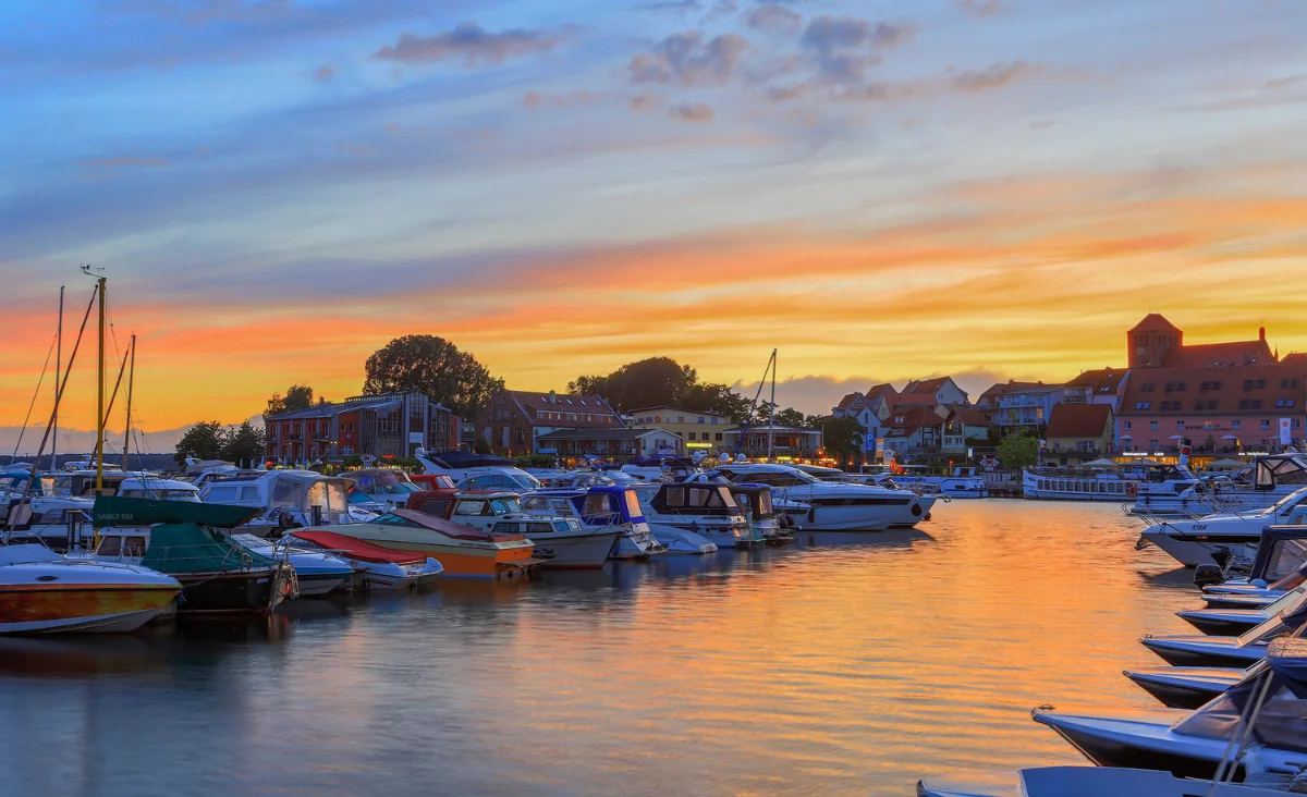 Wunderschöner Sonnenuntergang über dem 5 Sterne Resort Müritz, mit warmen Farben am Himmel.