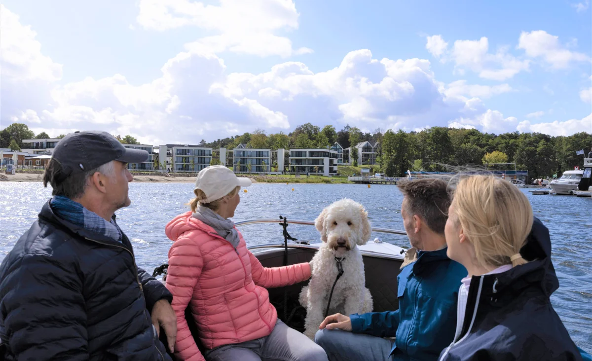 Eine Gruppe von Menschen auf einem Boot mit einem Hund, aufgenommen im 5 Sterne Resort Müritz.