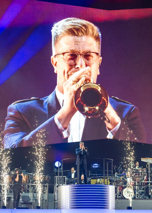 Ein Mann im Anzug spielt Trompete auf der Bühne beim Musikfest der Bundeswehr.