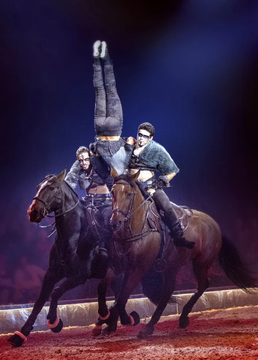 Ein Mann auf einem Pferd führt einen beeindruckenden Trick während der CAVALLUNA-Show in Berlin auf.