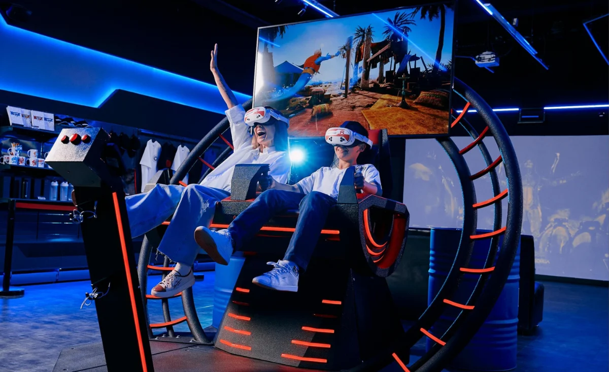 Zwei Personen sitzen auf einer Virtual-Reality-Maschine im Virtual-Reality-Park für vier Personen.