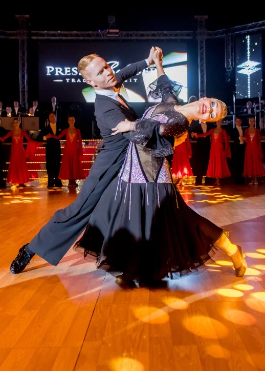 Ein Paar tanzt in einem Ballsaal mit einer Bühne im Hintergrund beim Presseball Berlin 2026.