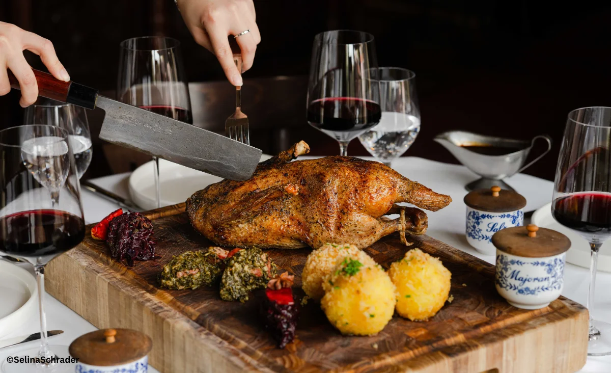 Eine Person schneidet einen Truthahn auf einem Schneidebrett in der Ganymed Brasserie.