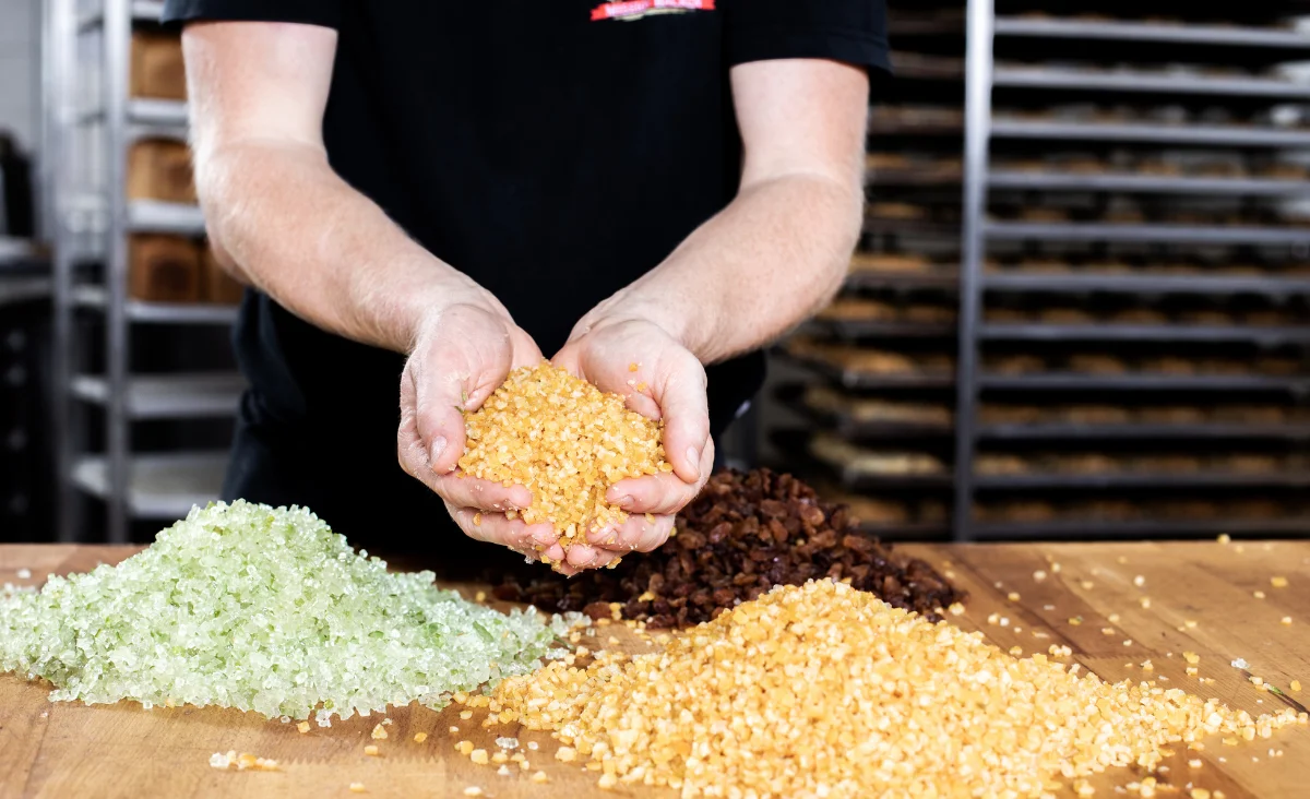 Ein Mann präsentiert Mais in seinen Händen, aufgenommen vor der Stollenbäckerei Krause in Dresden.