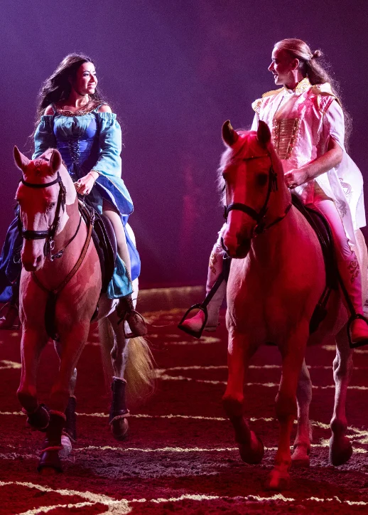 Zwei Frauen reiten auf Pferden während der CAVALLUNA-Show in Düsseldorf im Zirkus.