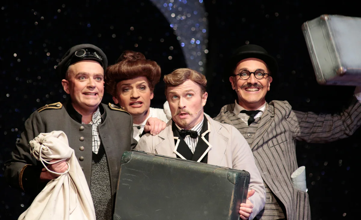 Kostümierte Personen mit Koffern stehen vor dem Tipi am Kanzleramt in Berlin, bereit für die Aufführung von Frau Luna.