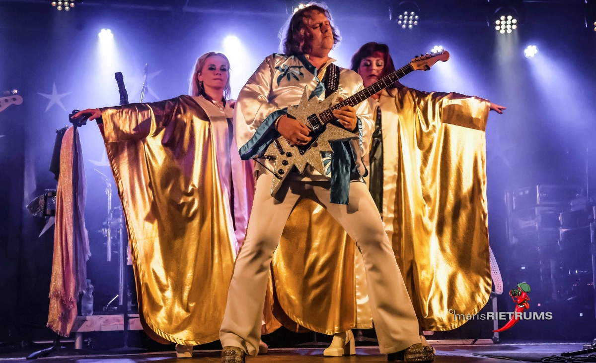 Die Band WATERLOO THE ABBA SHOW tritt auf der Bühne in goldenen Outfits auf.