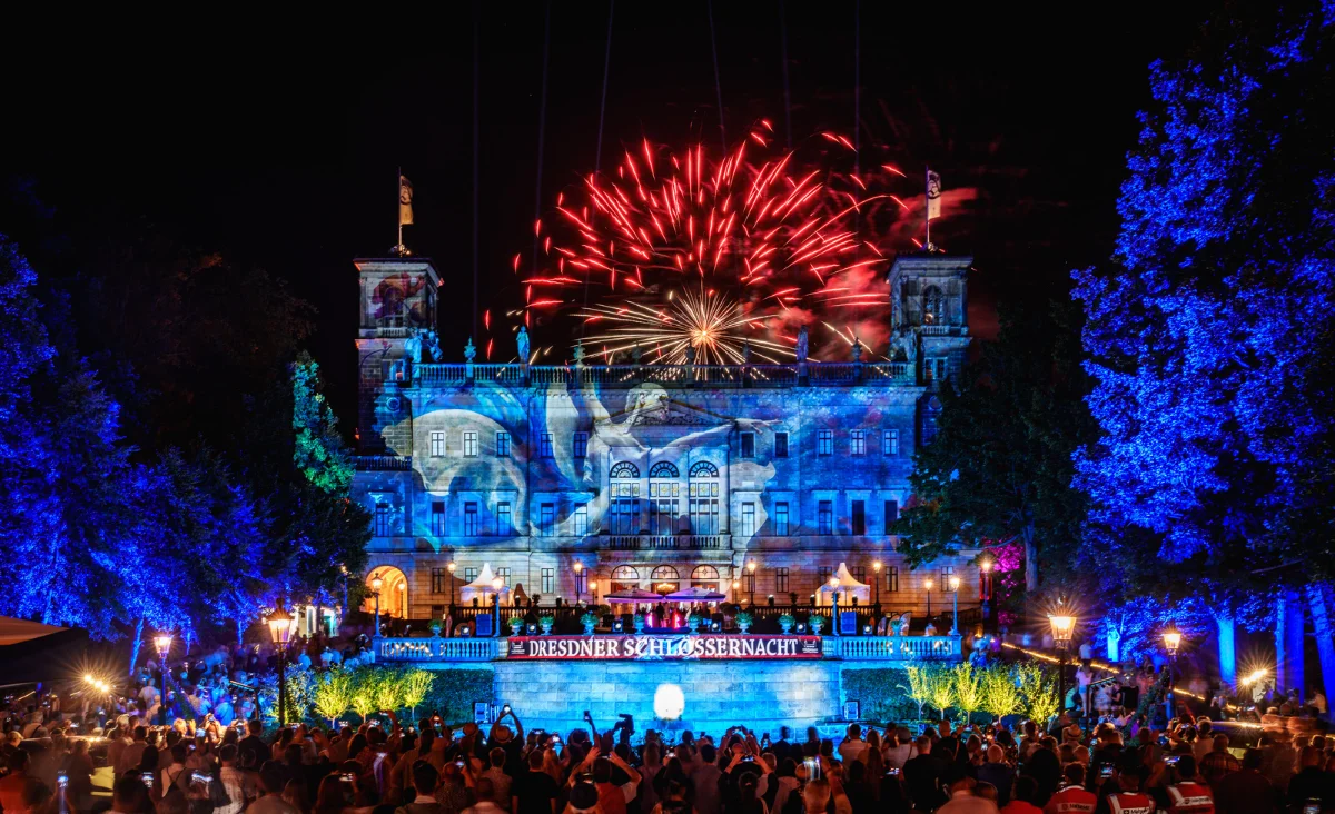 Ein großes Gebäude beleuchtet während der Dresdner Schlößernacht Lichtershow und Feuerwerk im Hintergrund