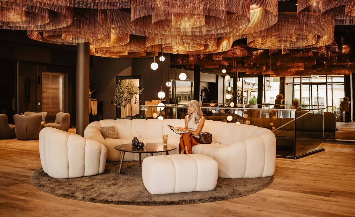 Moderne und elegante Lobby-Lounge im Hotel Bodenmaiser Hof mit gemütlichen weißen Sesseln und stilvoller Deckenbeleuchtung