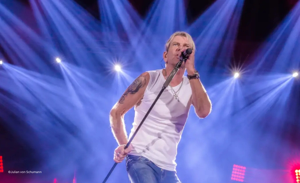 Matthias Reim singt leidenschaftlich live auf der Bühne im hellen Scheinwerferlicht